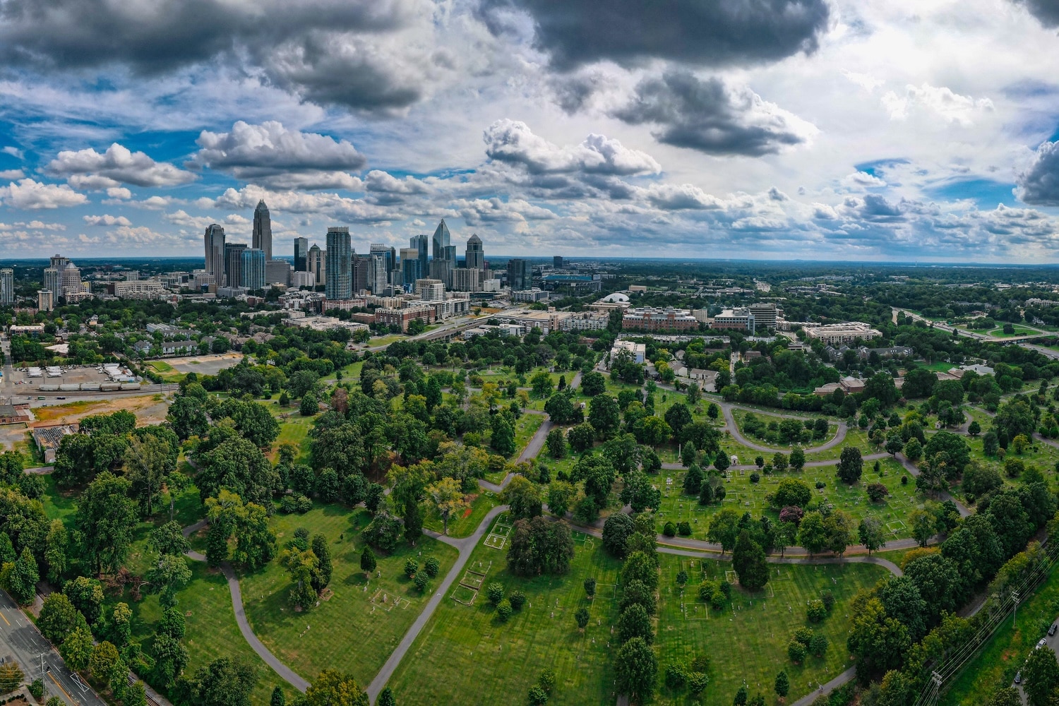 An aerial view of Charlotte, North Carolina's downtown and greenery on a partly cloudy day